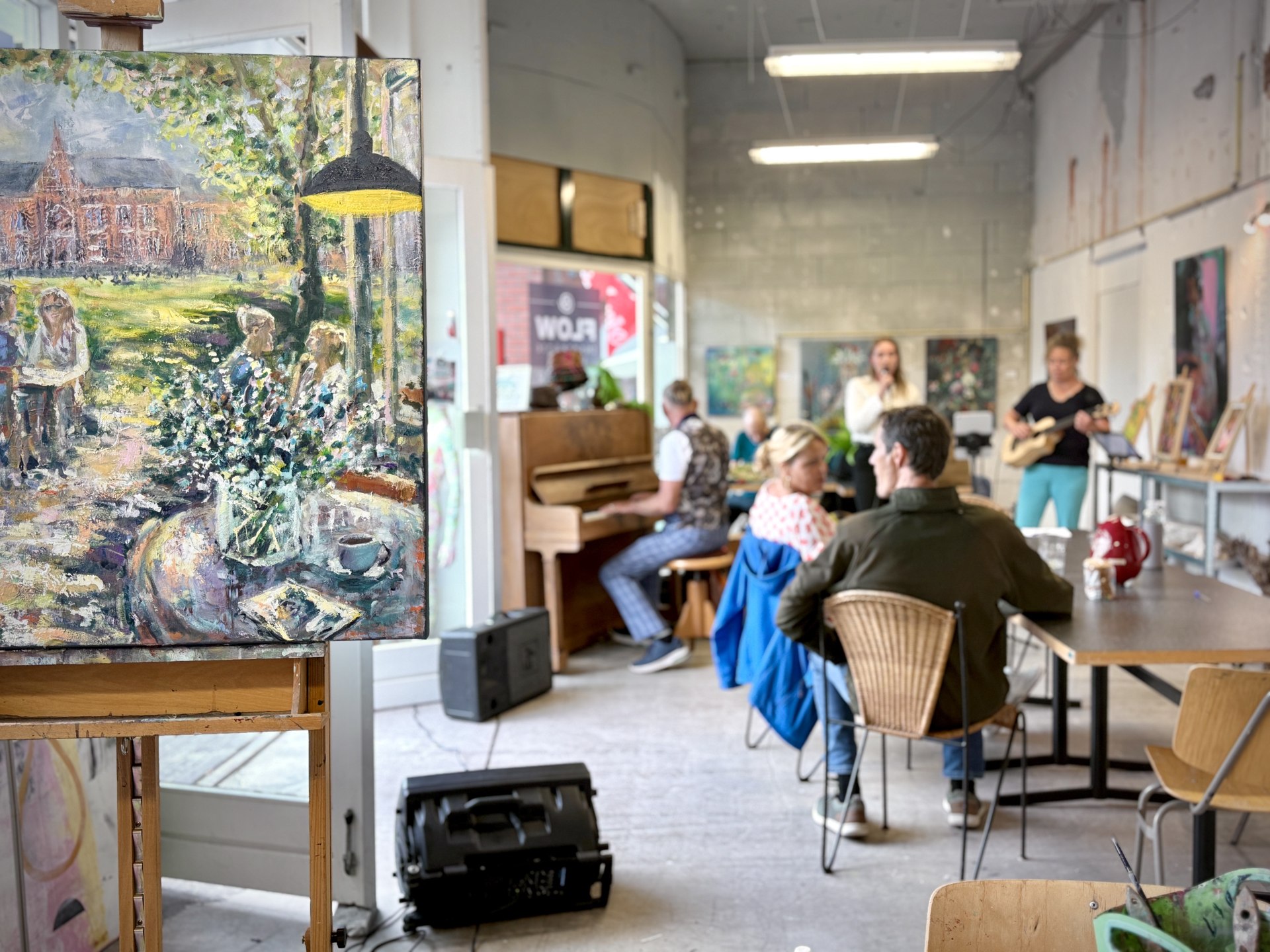 Kunst, bezoekers en live muziek in de atelier-galerie van FLOW